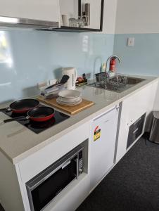 普拉瑟潘PROSERPINE MOTOR LODGE的厨房配有带炉灶和水槽的台面