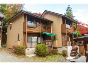 大石Lake Kawaguchi Rental Villa Tozawa Center - Vacation STAY 46833v的公寓大楼设有门廊和阳台。