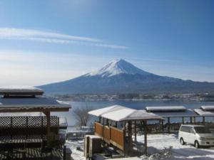 大石Lake Kawaguchi Rental Villa Tozawa Center - Vacation STAY 46680v的一座白雪覆盖的山,有一座有雪覆盖的建筑