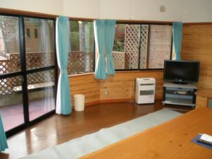 大石Lake Kawaguchi Rental Villa Tozawa Center - Vacation STAY 46845v的客厅配有蓝色窗帘和电视