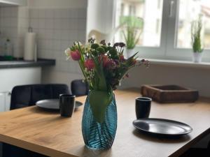 莱比锡Charmante Wohnung in der Südvorstadt的花瓶,花朵放在桌子上
