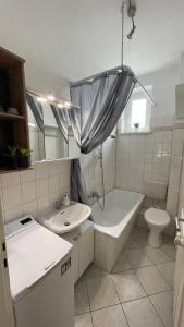 莱比锡Charmante Wohnung in der Südvorstadt的一间带水槽、浴缸和卫生间的浴室