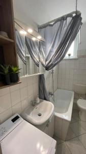 莱比锡Charmante Wohnung in der Südvorstadt的浴室配有盥洗盆、卫生间和浴缸。