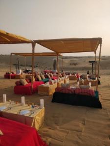 斋沙默尔Desert Camps Heritage Jaisalmer的沙漠沙中的一组桌子