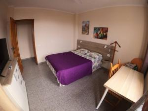 拉克鲁斯Double Room at Villa Lila的一间卧室配有一张紫色的床和一张桌子