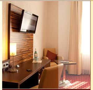 本斯海姆珀斯图本餐厅酒店的酒店客房设有一张桌子,墙上配有电视