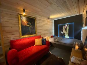 博福特Tailor's Trail gîte d'adventure Beaufort Mullerthal的客厅配有红色的沙发和床。
