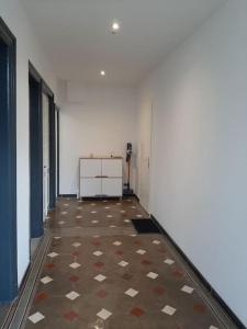 勒米尔蒙Chambre privée Au pied des Vosges的一间空的走廊,房间铺着瓷砖地板