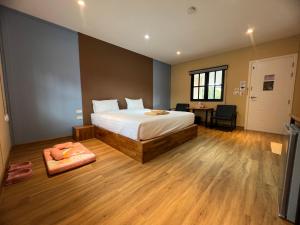 达叻府Napdown Resort Trat นับดาว รีสอร์ท ตราด的一间卧室配有一张床、一张桌子和一张桌子