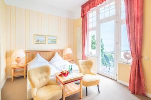 赛巴特班森Strandhotel Möwe的酒店客房带一张床、一张桌子和椅子