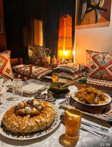 瓦尔扎扎特Le Petit Riad Maison d'hôtes的一张桌子,上面放着盘子和馅饼