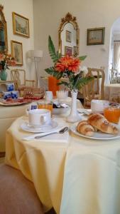 威尼斯卡瑞奇欧酒店的一张桌子,上面放着盘子和羊角面包
