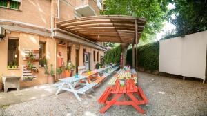 比萨Safestay Pisa Centrale的一组野餐桌,放在木制伞下