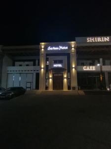 布哈拉Sarbon Plaza Hotel的夜间在建筑物前的商店