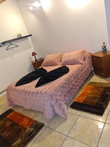 PegarinhosCasa da Oliveira的卧室配有一张床,地板上铺有2个地毯。