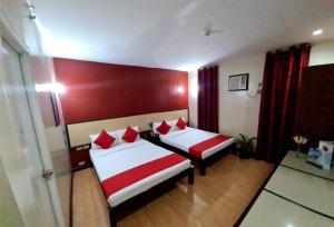 马尼拉Asiatel Airport Hotel的一间卧室配有两张红色和白色床单
