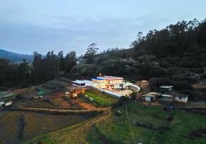 乌提Silent Retreat Ooty Farm Resort by VOYE HOMES的山丘上房屋的空中景致