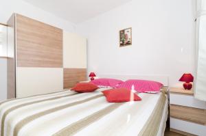 杜布罗夫尼克Sea View Apartment Nuncijata的一间卧室配有一张带红色枕头的大床