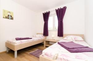 杜布罗夫尼克Sea View Apartment Nuncijata的紫色窗帘间内的两张床
