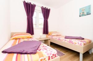 杜布罗夫尼克Sea View Apartment Nuncijata的卧室内的两张床,配有紫色窗帘