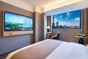广州广州兰欧国际酒店的酒店客房的墙上设有大屏幕电视