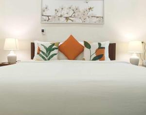 爱妮岛Kudugman Beach Cottages - El Nido的卧室配有带枕头的大型白色床