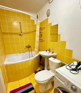 罗夫诺4-км в центрі міста的黄色的浴室设有卫生间和水槽