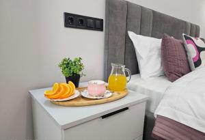阿拉木图ЖК Комфорт Сити Бизнес, 2 room Apartment 47的床头柜上放有橘子和果汁的托盘