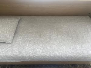 洛桑Le Sami的一张带白色床单和枕头的床