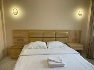 西哈努克西港宾馆的一间卧室配有一张床,上面有两条毛巾