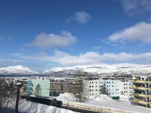 特罗姆瑟Your home away from home, apartment 1的享有雪覆盖的山脉的城市美景