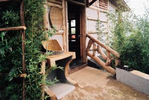 KinkiziBwindi My Home的一座带木楼梯的房屋,配有长凳和植物