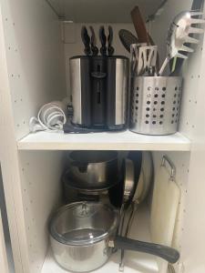 洛桑Le Sami的一个带咖啡壶和餐具的厨房架