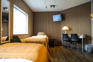 阿克雷里Akureyri Hostel的酒店客房设有两张床和一台墙上的电视。