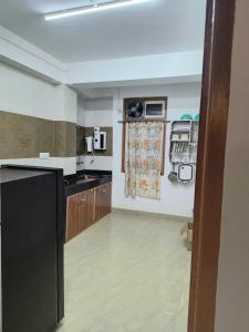 甘托克Natures Life urban homestay的厨房配有黑色冰箱和木制橱柜。