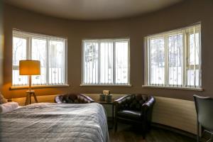 阿克雷里Akureyri Hostel的一间卧室配有一张床、椅子和窗户。