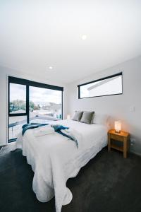 Charming Retreat in the Heart of Christchurch City-CBD的白色的卧室设有一张大床和一个窗户