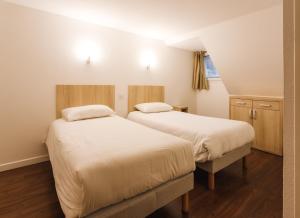 科特雷Garden & City Cauterets Balneo的铺有木地板的小客房内的两张床