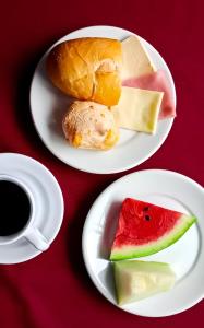 德尔菲诺波利斯HOTEL JP的两盘带食物和咖啡的白盘