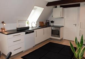 里伯Lejlighed med et eller to separate soveværelser的厨房配有白色橱柜、水槽和窗户。