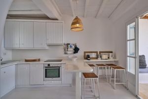卡拉法蒂斯Villa Sea Angels的厨房配有白色橱柜和吊灯