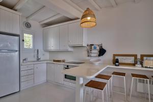 卡拉法蒂斯Villa Sea Angels的厨房配有白色橱柜和灯具