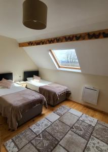 Bersac-sur-RivalierVue Du Vallon的阁楼卧室设有两张床和窗户。