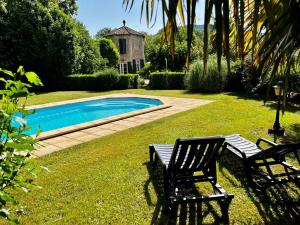 昂迪兹Les Gîtes et la Chambre de Labahou SPA的一个带两把椅子的庭院和一个游泳池