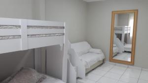 马蒂尼奥斯Espaço de praia acolhedor para família e pets的一间卧室配有双层床和镜子