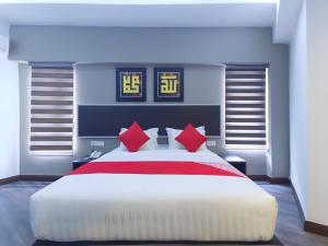吉隆坡RPC Blissful Homes & Hotel的卧室配有带红色枕头的大型白色床
