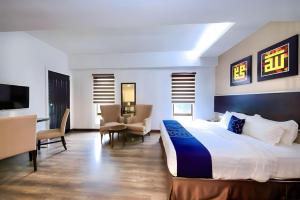 吉隆坡RPC Blissful Homes & Hotel的酒店客房配有床、椅子和电视。
