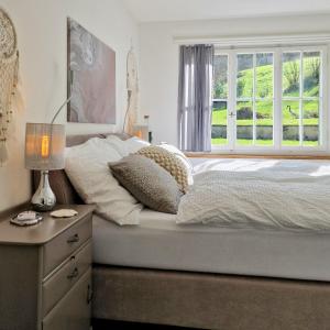罗尔沙赫伯格peaceful tiny house near forest的一间卧室配有一张带窗户和梳妆台的床