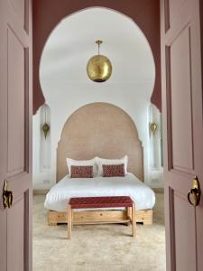 马拉喀什Riad Fisaline en exclusivité pour vous à Marrakech的一间卧室配有一张大床和大床头板