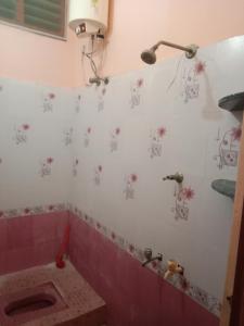 蒂鲁瓦纳马莱SriArunachala Shiva home stay的浴室设有粉红色的浴缸,墙上挂着鲜花